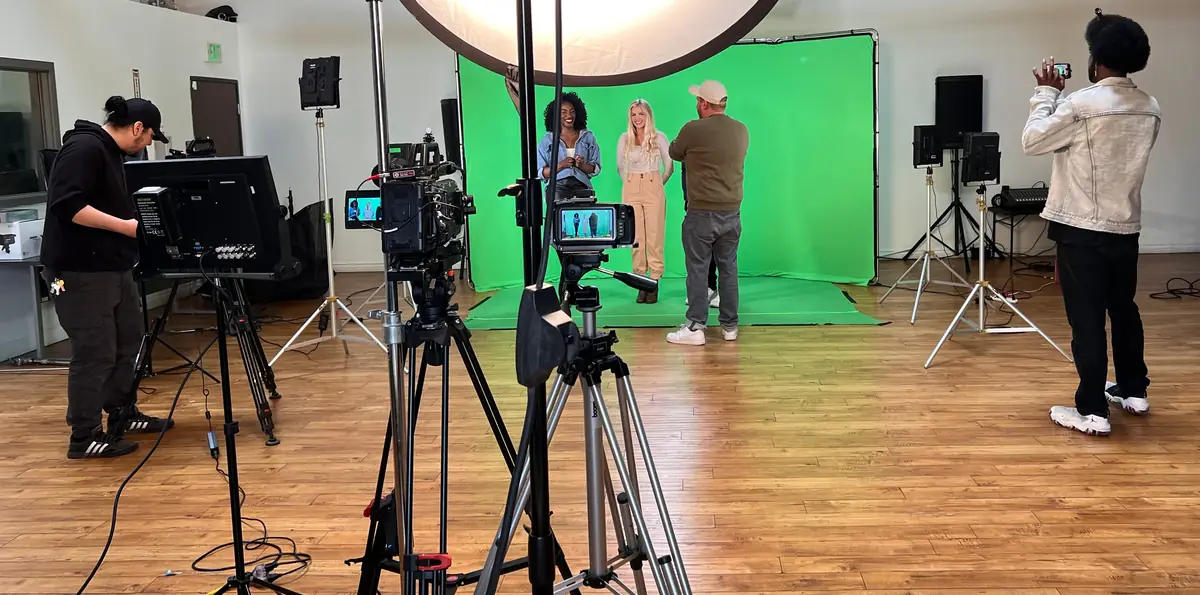 On location: a compact green screen build inside a client space with two presenters, camera, prompter and lighting